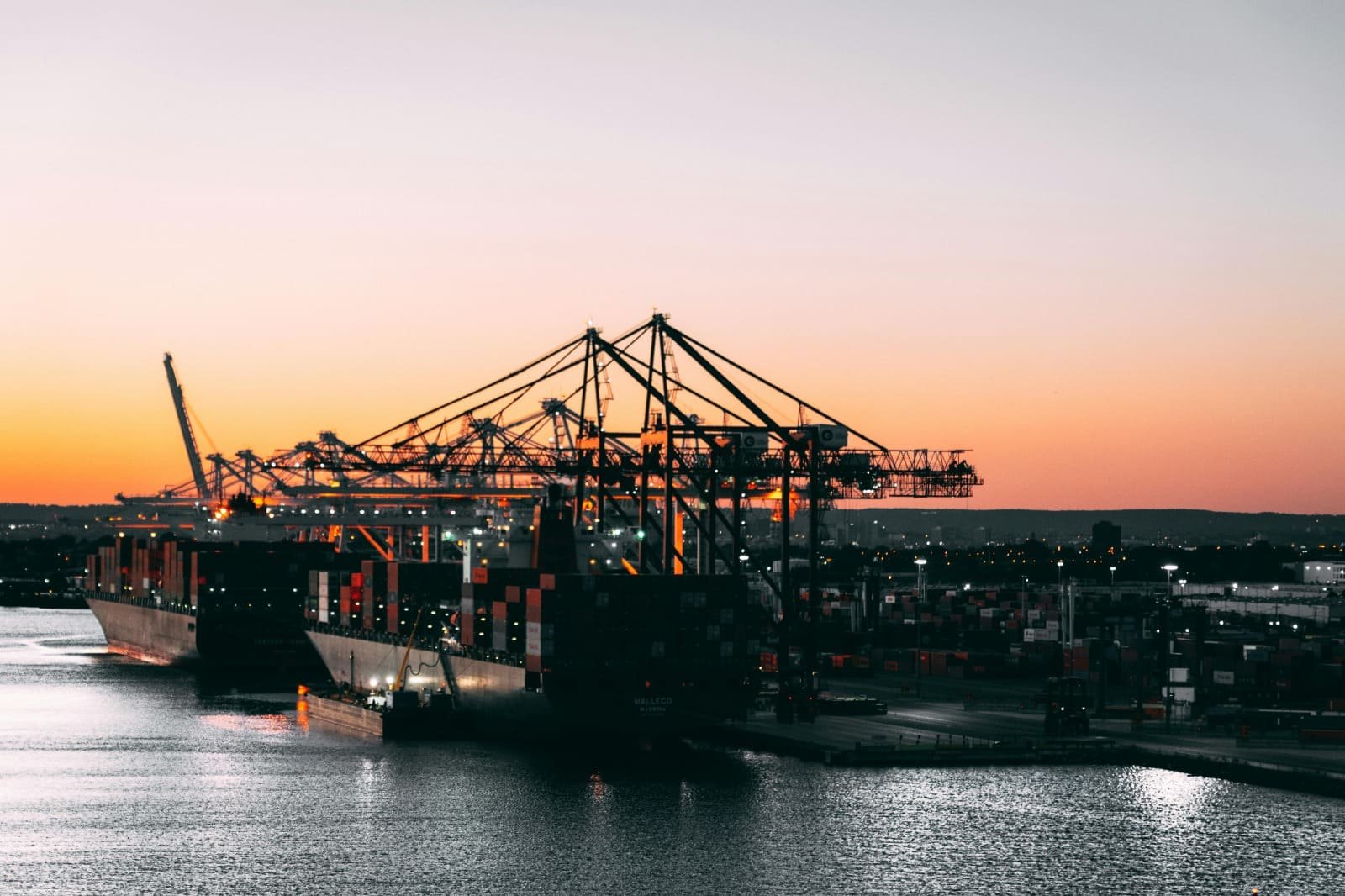 Terminal portuaria con buques de carga al atardecer